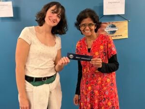 Charlie awards Nimmi a Best Speakers ribbon